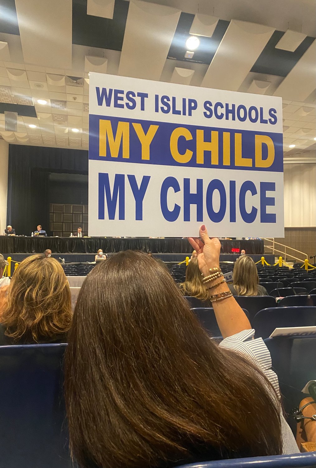 A parent holds up a sign during the West Islip Board of Education meeting on Aug. 12.